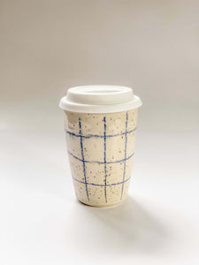 Wheel thrown travel mug in cream and brown speckled clay with hand drawn blue graph paper design 