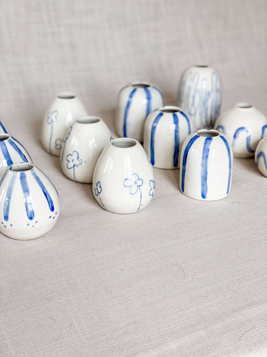 collection handmade porcelain blue white bud vases lined up in 4 rows