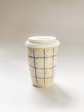 Load image into Gallery viewer, Wheel thrown travel mug in cream and brown speckled clay with hand drawn blue graph paper design 
