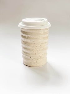 Wheel thrown travel mug in cream and brown speckled clay with hand painted subtle matte curving line design