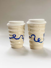 Load image into Gallery viewer, Two wheel thrown travel mugs in cream and brown speckled clay with hand painted blue curving line design 