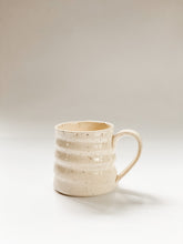 Load image into Gallery viewer, Wheel thrown mug with pronounced spiral throwing marks in cream and brown speckled clay  
