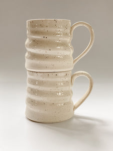 Two stacked wheel thrown mug with pronounced spiral throwing marks in cream and brown speckled clay  