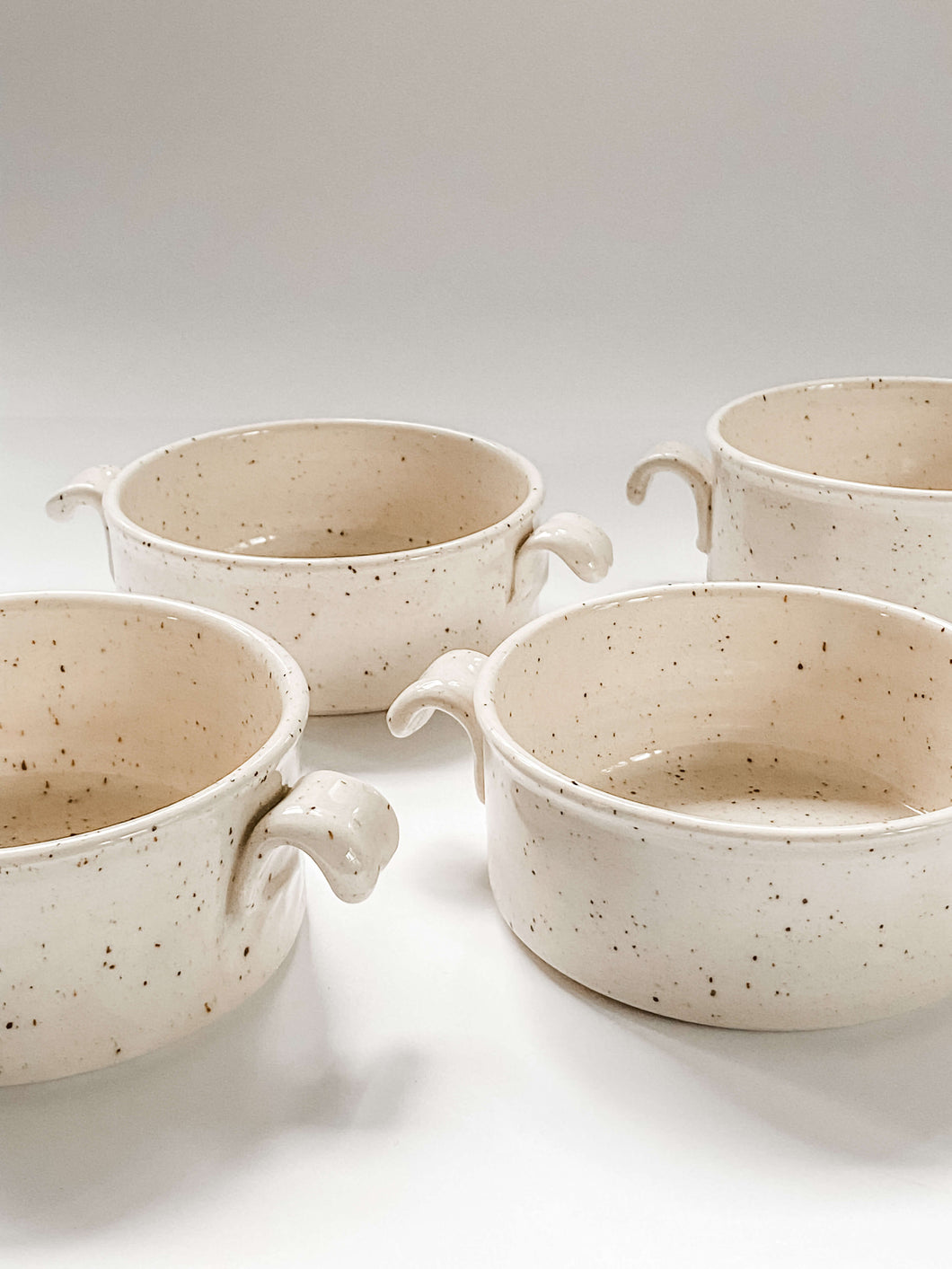 4 Wheel thrown cylindrical soup bowls with two hooked handles in a cream and brown speckled clay