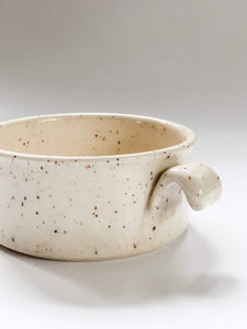 Close up of handle on wheel thrown cylindrical soup bowls with two hooked handles in a cream and brown speckled clay