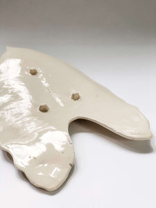 Underside of leaf platter in white porcelain clay showing 3 feet and small imperfections